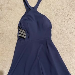 Selling a navy blue dress with rhinestones stripes on the side.